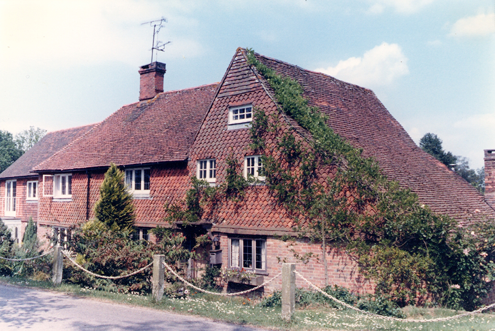 17th-century cottage with catslide roof on the right; repeated extensions to the left in the 18th century (Felbridge).